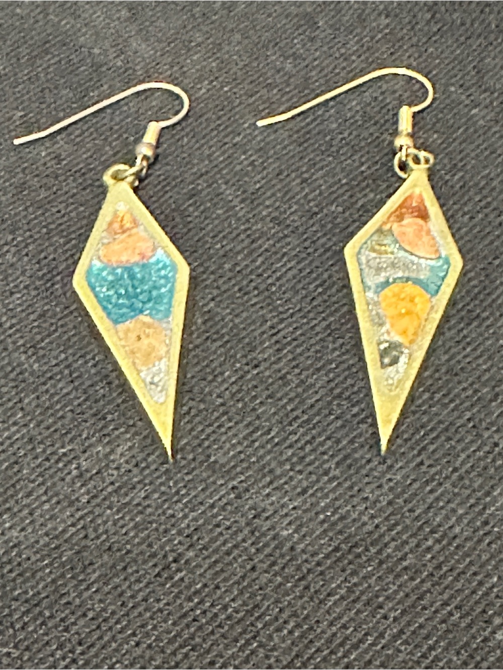 These dangling earrings feature a striking elongated diamond frame